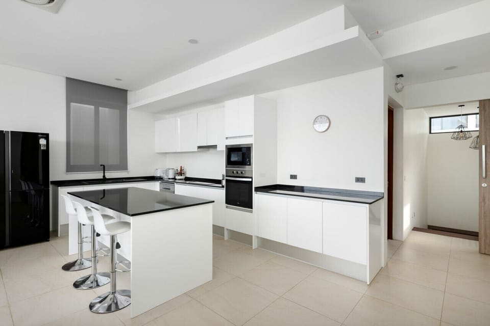 Fully-equipped European-style kitchen with modern island and premium appliances - perfect for family meals