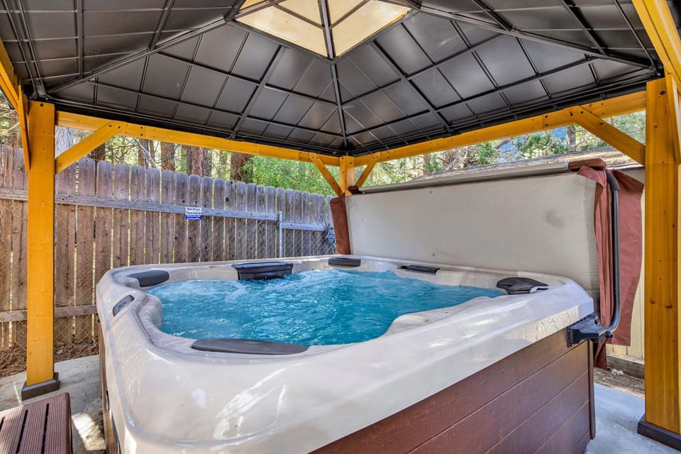 Private outdoor hot tub, surrounded by tall pines, perfect for relaxing under the trees after a day of adventure—enjoy peaceful forest views, fresh air, and a truly rejuvenating stay.