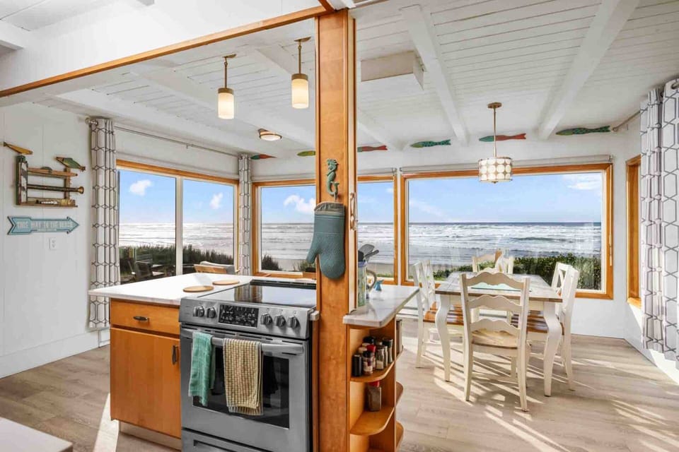 The adjacent dining/sitting room, complete with comfy seating, offers panoramic views of the coastline.