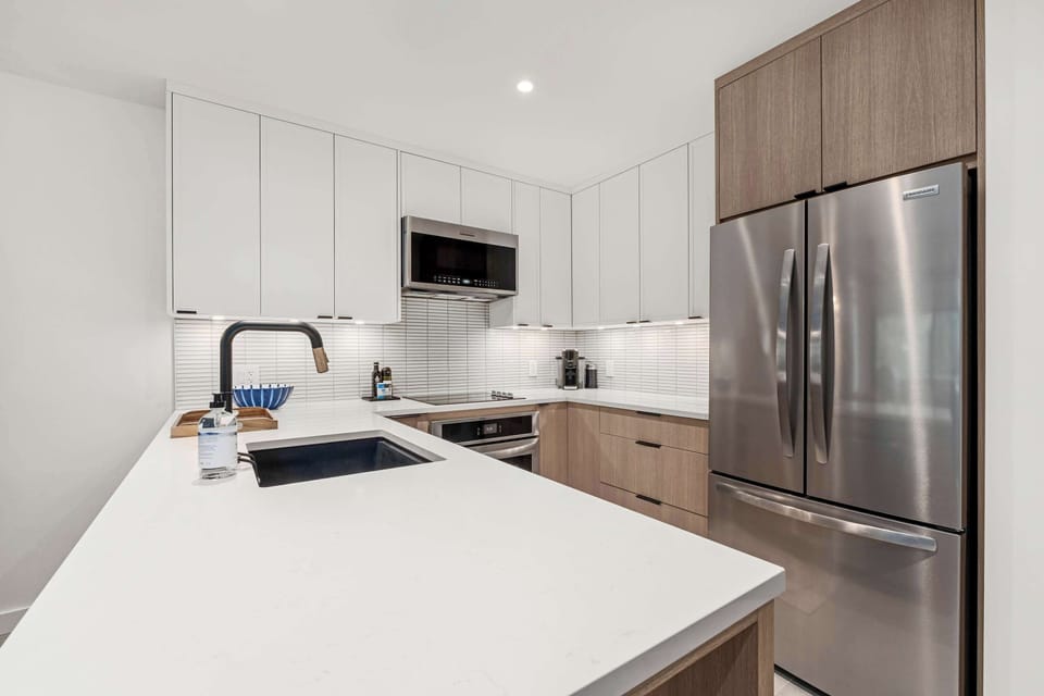 - Open kitchen with granite counters and stainless appliances for easy meal prep - Spacious layout ideal for groups seeking comfort and convenience - Warm wood accents create a modern mountain home cooking space
