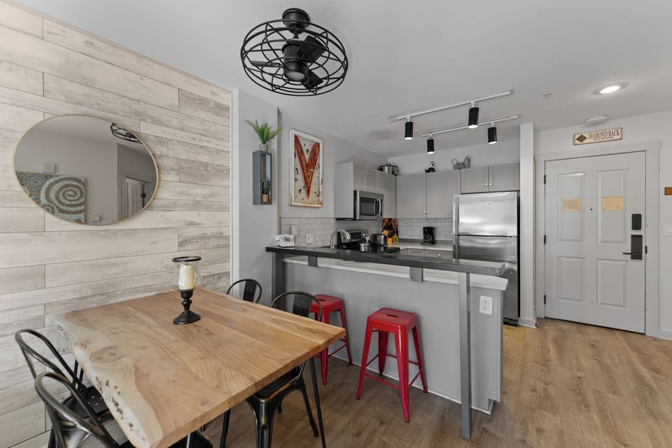 Step into your stylish open-plan space where modern design meets comfort. Gather around the warm wood table or perch at the sleek breakfast bar.