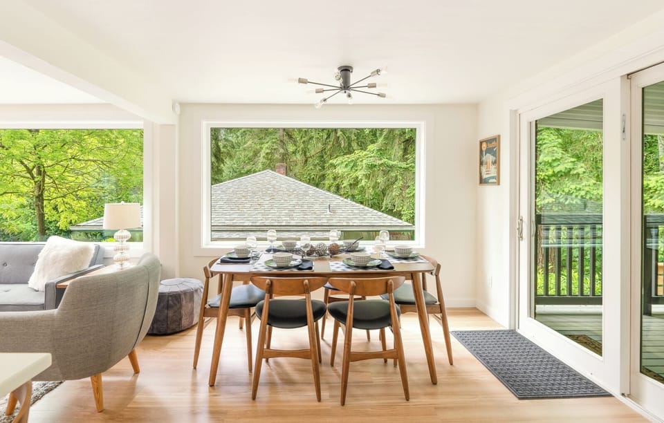 - Bright dining space with forest views through large window  
- Wooden table set for meals with friends or family gatherings  
- Enjoy shared moments in this naturally lit dining area  
