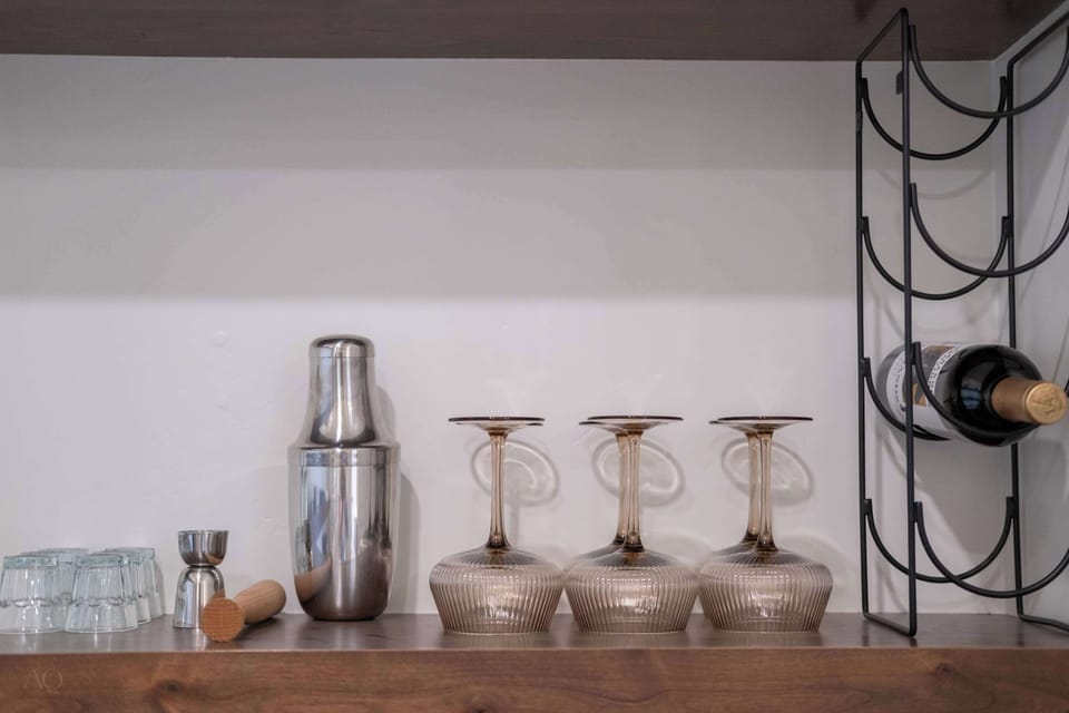 Thoughtfully styled bar setup with wine rack, glassware, and cocktail tools for elevated evenings in.