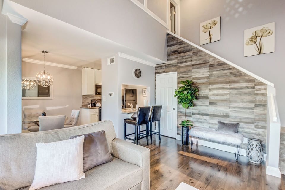 Airy living area with high ceilings, plenty of seating and natural lighting.