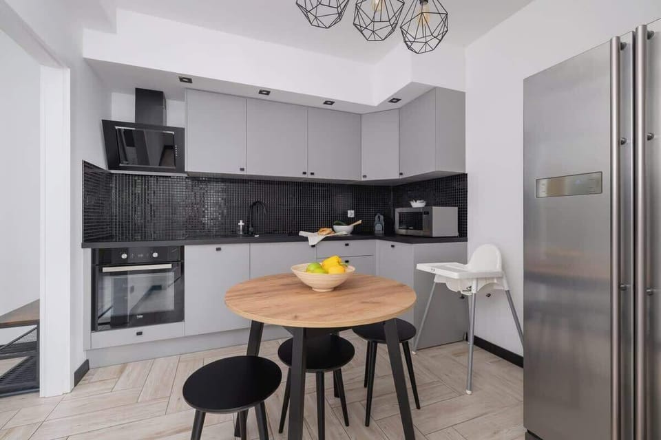 A modern, fully equipped kitchen with a round dining table and black cabinetry. Ideal for preparing meals and enjoying breakfast together.