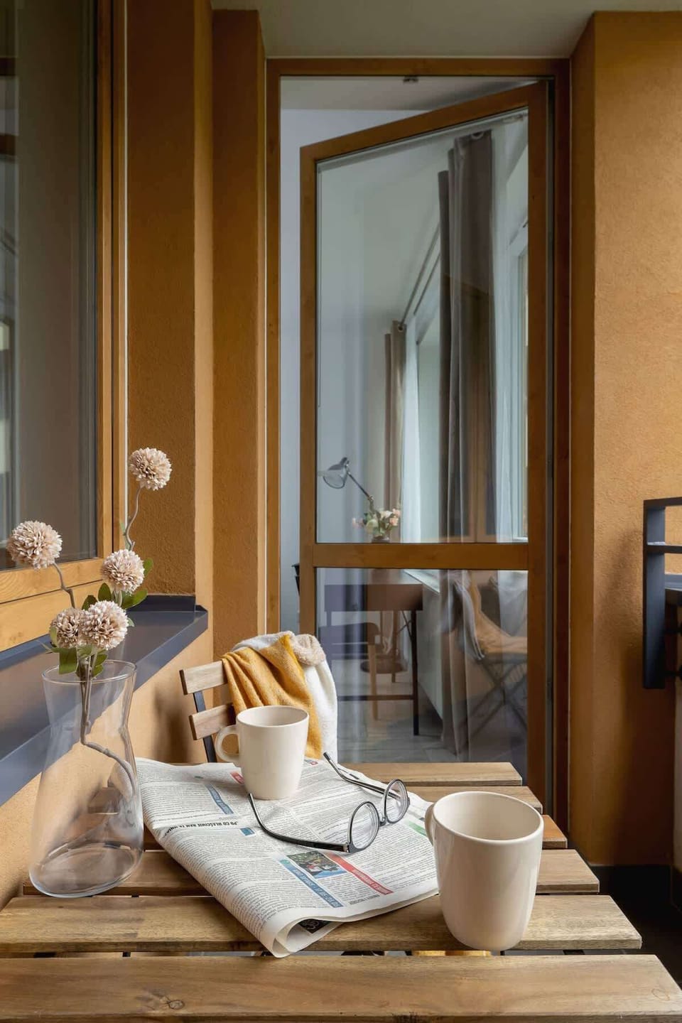 A close-up of a beautifully set dining table near a balcony. Elegant and inviting dining experience.
