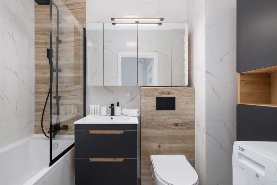 A sleek bathroom featuring a walk-in shower, elegant tiles, and modern fixtures. Compact yet comfortable.