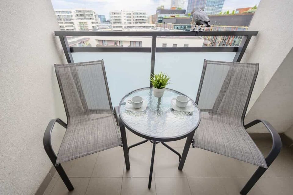 Spacious balcony with outdoor furniture. 