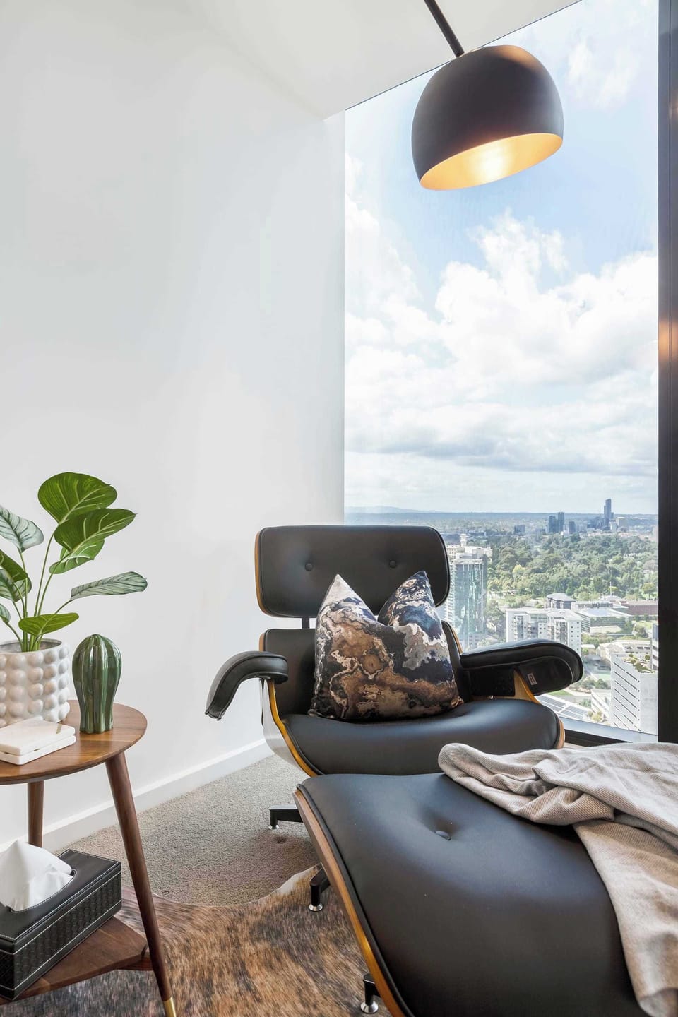 LIVING ROOM: Perched above the city streets, this lounge offers a serene escape where plush seating and expansive windows frame breathtaking panoramic views.
