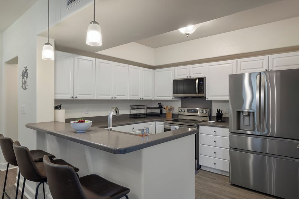 Your spacious kitchen awaits with gleaming stainless steel appliances, granite counters, and a breakfast bar perfect for morning coffee.