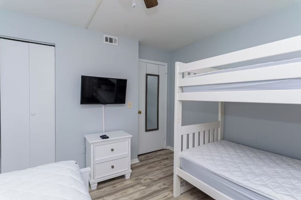 Bedroom view with closet, TV, dresser and mirror