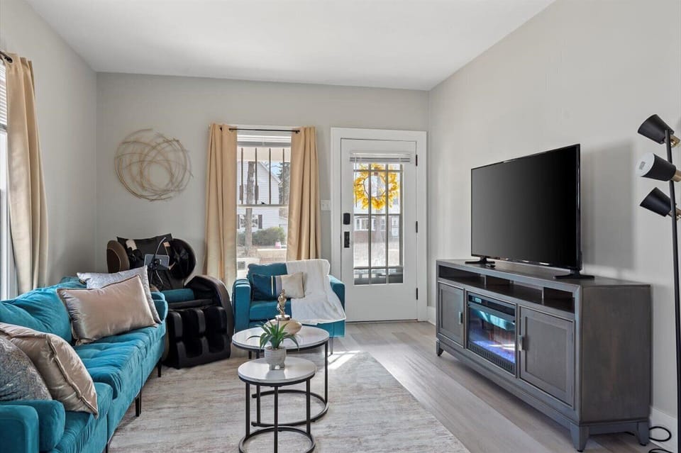 Living room with a smart tv, fire place and a luxurious massage chair.