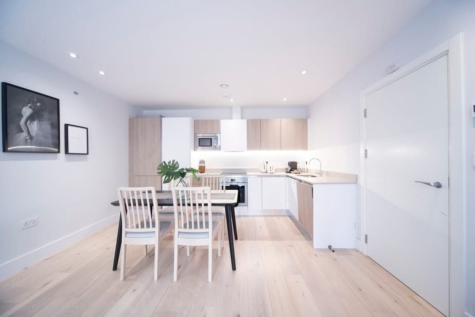The fully equipped kitchen has an oven and induction hob, microwave, kettle, toaster, dishwasher, Nespresso machine, and a dining table with four chairs.