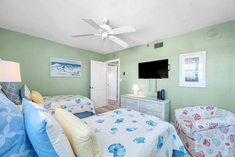 Spacious bedroom w/ twin beds, ceiling fan, & a TV for comfortable downtime.
