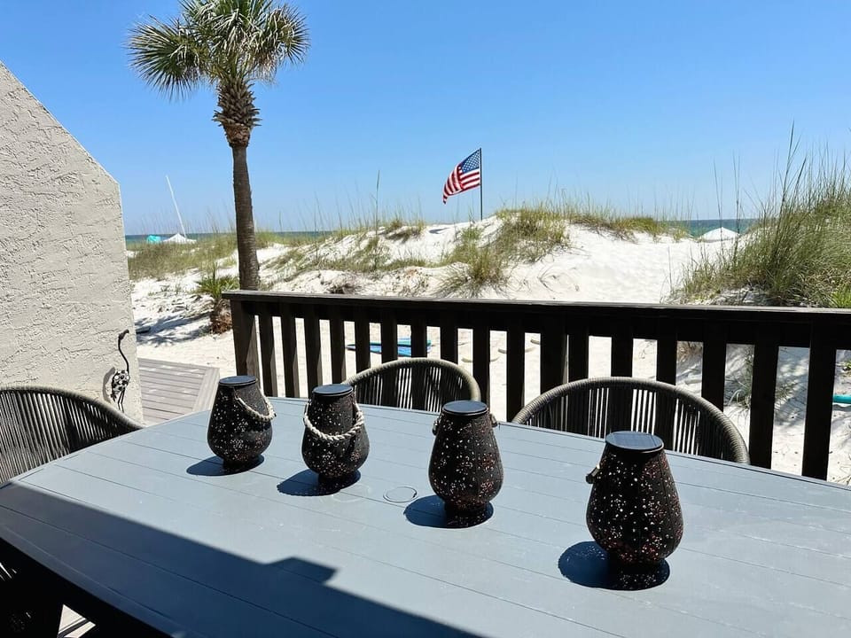 1st floor back patio table with seating for 6 and beach entrance.