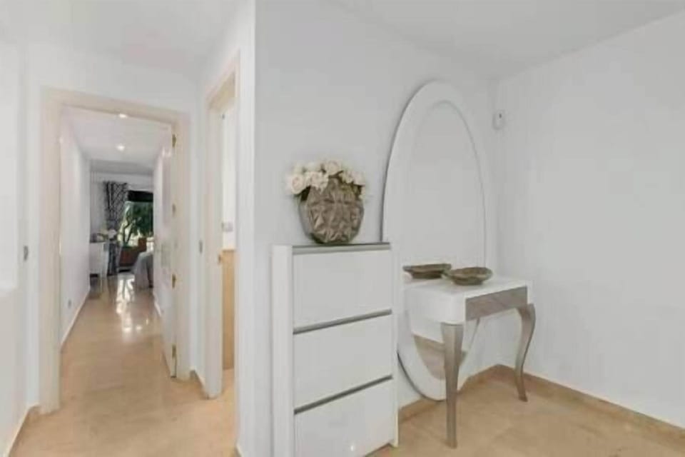 Apartment hall with mirror and chest of drawers.