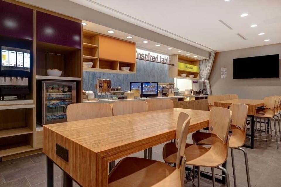 Gather for breakfast at roomy tables under warm, modern lighting.