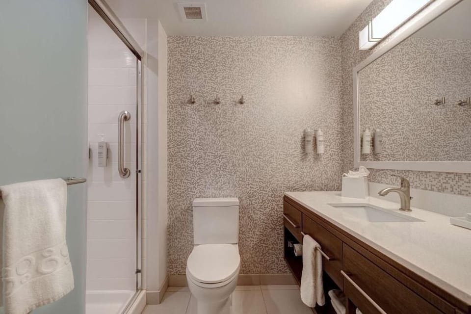 Refresh in a spotless bath with walk-in shower and plush towels.