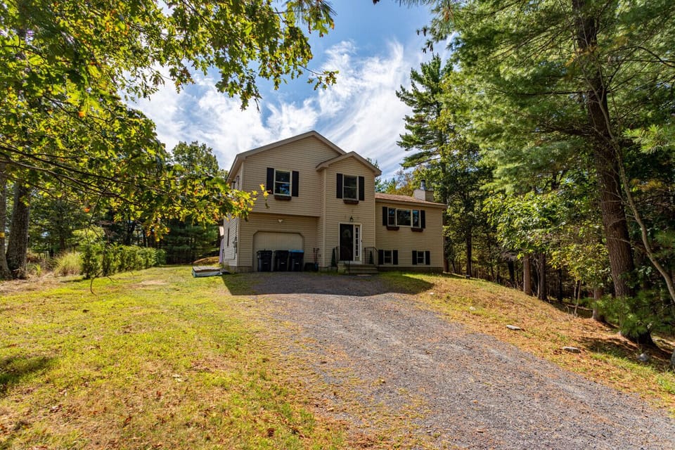 Spacious two-story home in the heart of the Poconos, surrounded by trees and open yard space for guests to enjoy