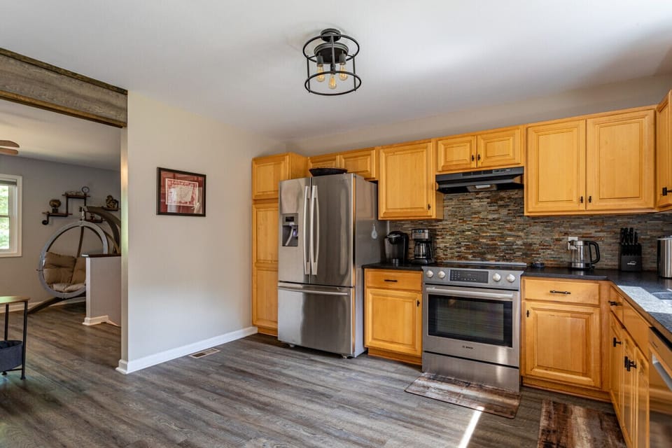 Bright kitchen with full-size refrigerator, oven, and coffee station, ideal for family meals in the Poconos.