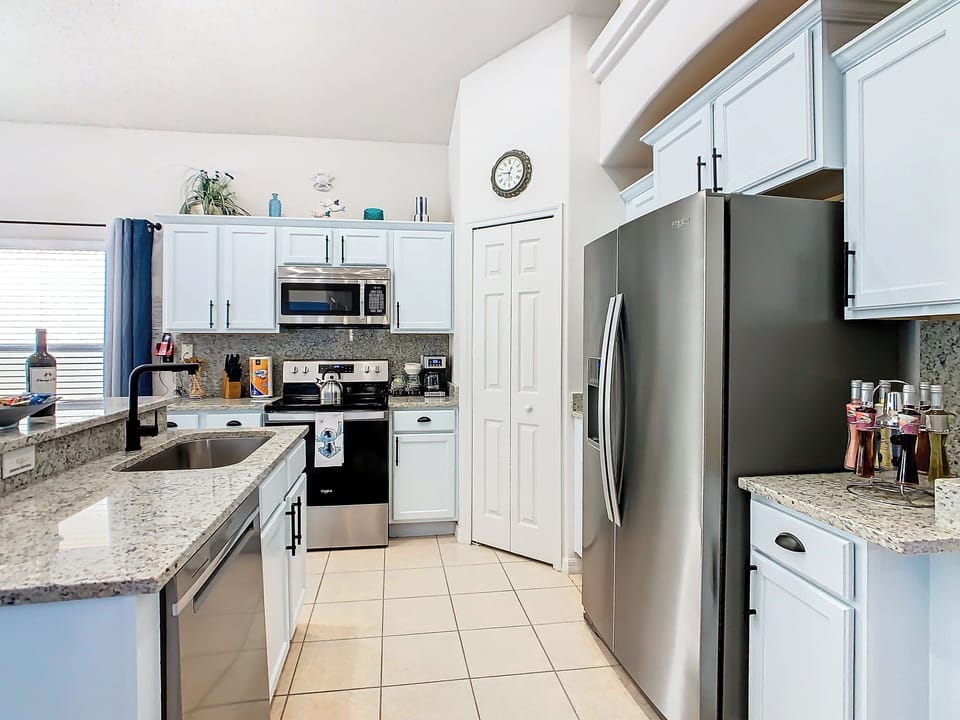 - Bright, modern kitchen with stylish granite counters and white cabinetry
- Stainless steel fridge, deep sink, and full cookware set for all your cooking needs
- Open layout connects to living and dining for effortless entertaining and flow