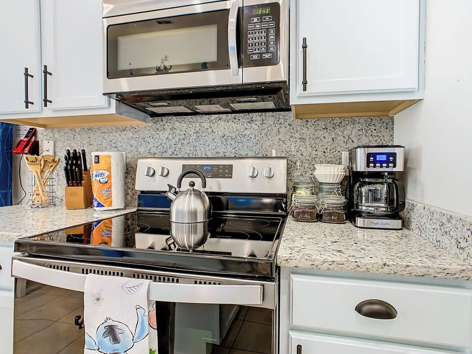 - Sleek stainless steel appliances including stove, microwave, and coffee station
- Fully stocked with utensils, cookware, and labeled jars for an organized touch
- Thoughtful setup makes meal prep, morning brews, and cleanup a breeze

