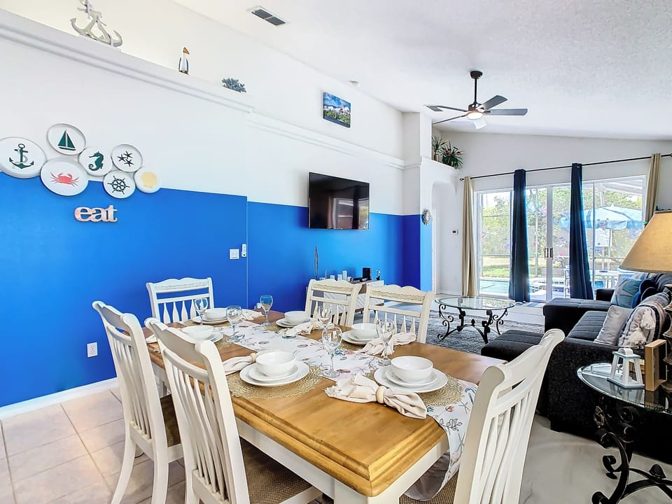 - Coastal themed dining room with seating for six and charming nautical wall accents
- Bright and airy space connects to the living room with views of the private pool
- Perfect for large family meals, celebrations, or relaxed conversation

