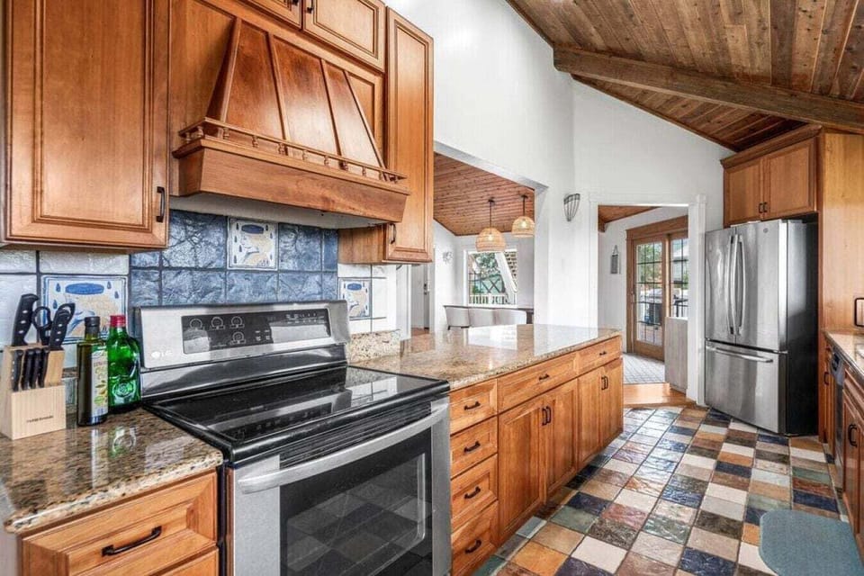 Your gourmet kitchen awaits with granite counters, premium appliances, and rustic wood beams creating the perfect space for memorable meals.