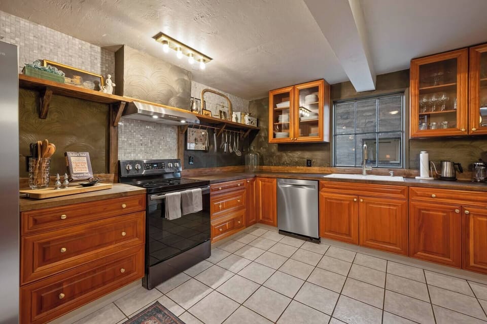 Kitchen includes oven, stovetop, dishwasher, farmhouse sink with disposal and a large refrigerator