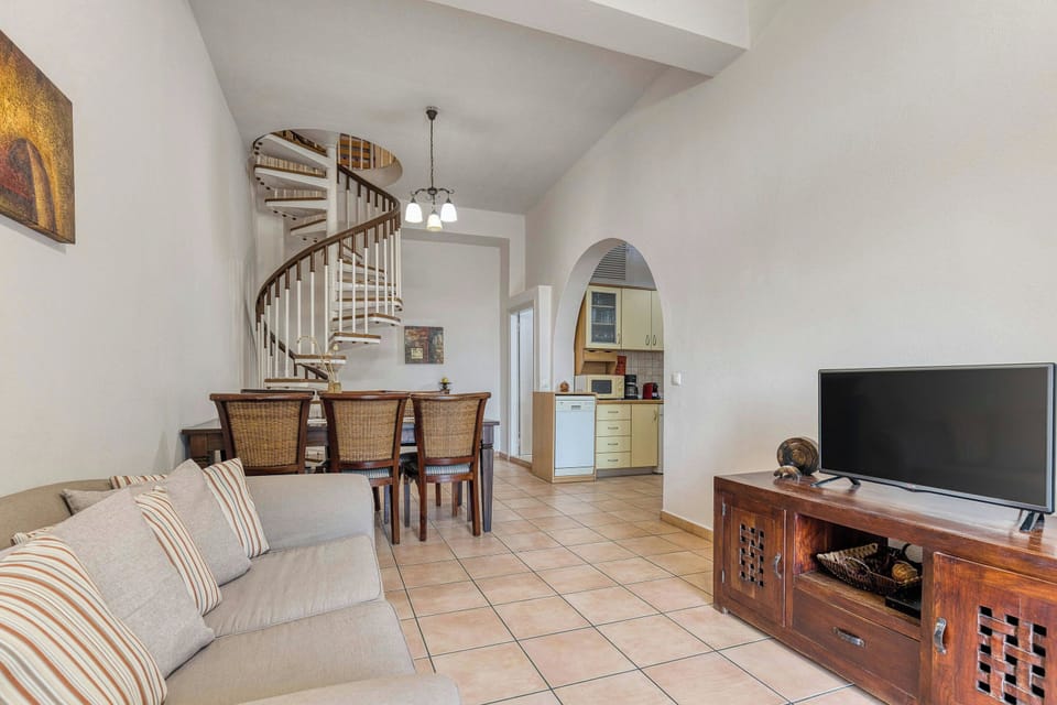 Spacious Living Room: A comfortable lounge area with a TV, perfect for relaxing after a day at the beach.