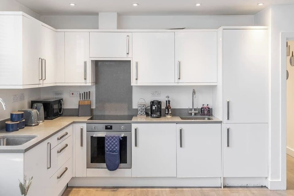 - Contemporary kitchen with ample storage and built-in appliances  
- Clean design with oven, fridge, kettle, toaster and essentials  
- Perfect setup for guests who love convenient cooking options  