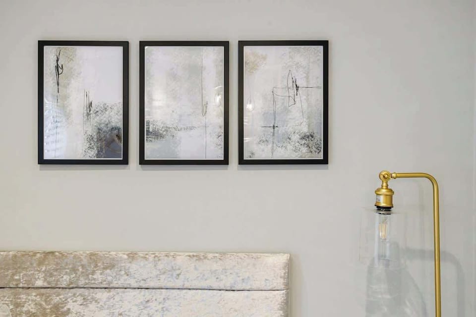 - Modern wall art with golden lamp adds stylish detail to bedroom  
- Minimalist decor enhances comfort and bright welcoming atmosphere  
- Perfect Airbnb touch combining design with restful cozy setting  
