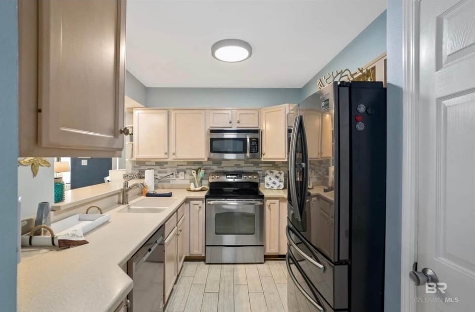 View of fully stocked kitchen w/stove, microwave, full size fridge, dishwasher, and Keurig