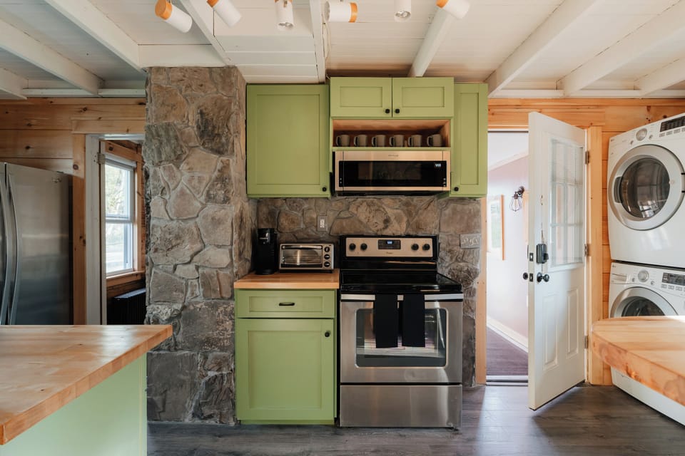 Wake up to the smell of fresh coffee and cozy cabin vibes — cook or brew beside the stone wall and rustic oven area designed for slow mornings.