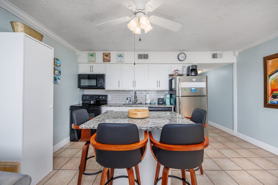 Full kitchen with island and breakfast bar set up with seating for 4