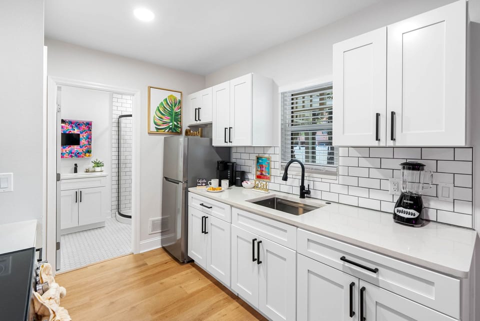 This sleek, all-white kitchen is a vision of contemporary design and functionality, crafted to cater to your every culinary need with style and precision.