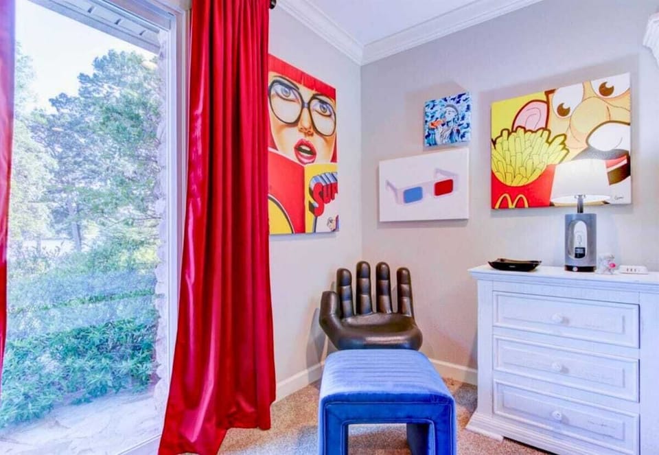 The bright red curtains provide a bold contrast to the neutral decor, adding a touch of drama and style.