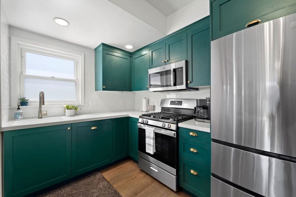 Stylish green kitchen w/ stainless appliances, clean lines & plenty of counter space for easy meals.