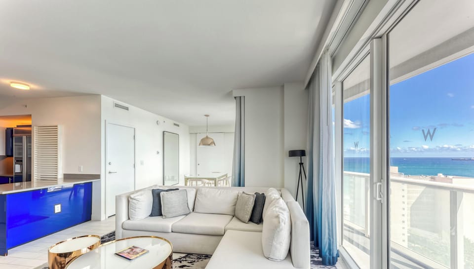 Full living space with Queen Size Sofa Pullout, Smart TV with Cable, Dining Table and multiple balconies all overlooking the ocean and intercoastal waterways.