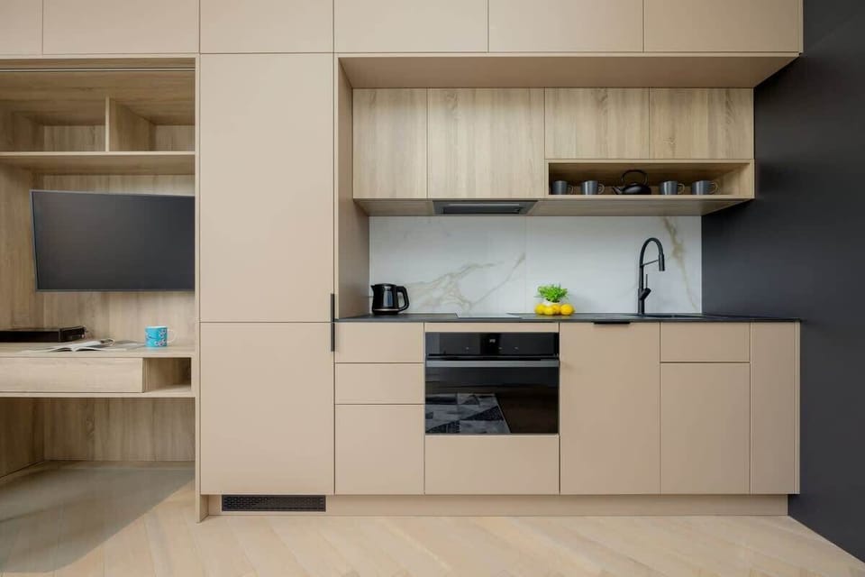 Kitchenette with built-in appliances – Integrated oven, induction hob, and elegant storage.

