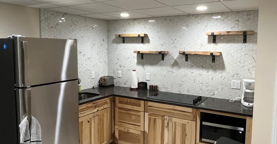 Kitchenette with custom backsplash and open shelves.