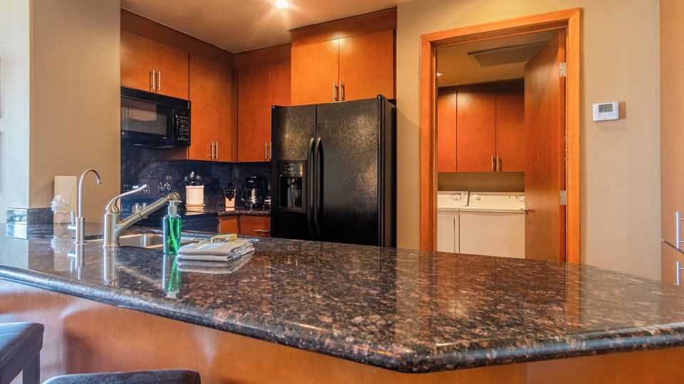 Dark granite and rich wood cabinets in the kitchen.