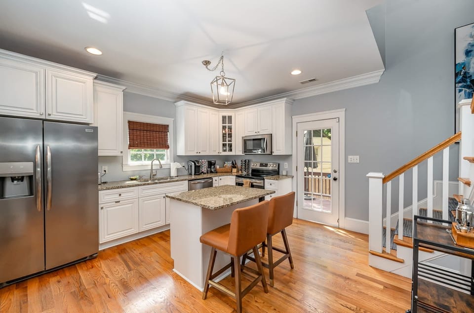 Step into our well-appointed kitchen featuring essential appliances like an oven, fridge, stove, and microwave, complete with comfortable seating for a convenient and enjoyable cooking environment