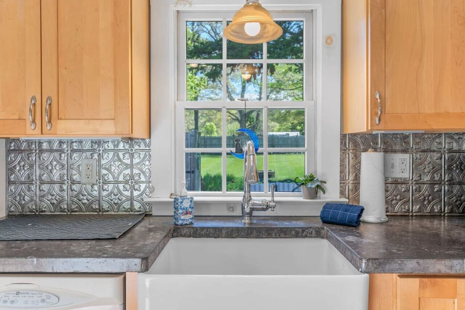 Enjoy the view of the backyard from the kitchen sink. We provide a drip coffee maker, filters, & coffee grounds for your morning routine.