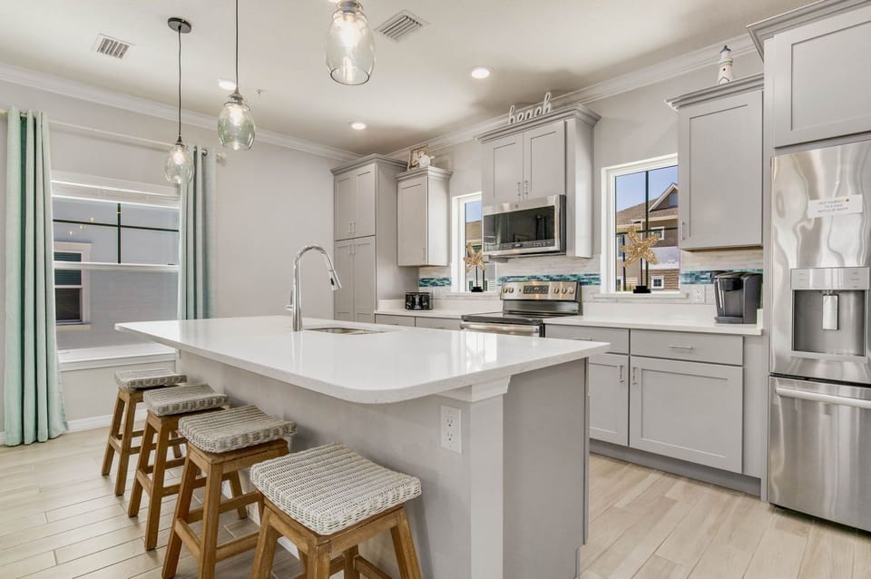 Gourmet kitchen with island seating and gas range at Battle Beach House pet-friendly rental