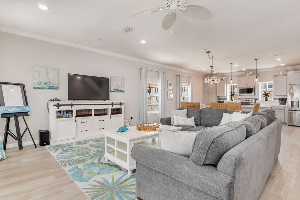 Open-concept living room with L-shaped sectional and balcony access at Lost Key townhome