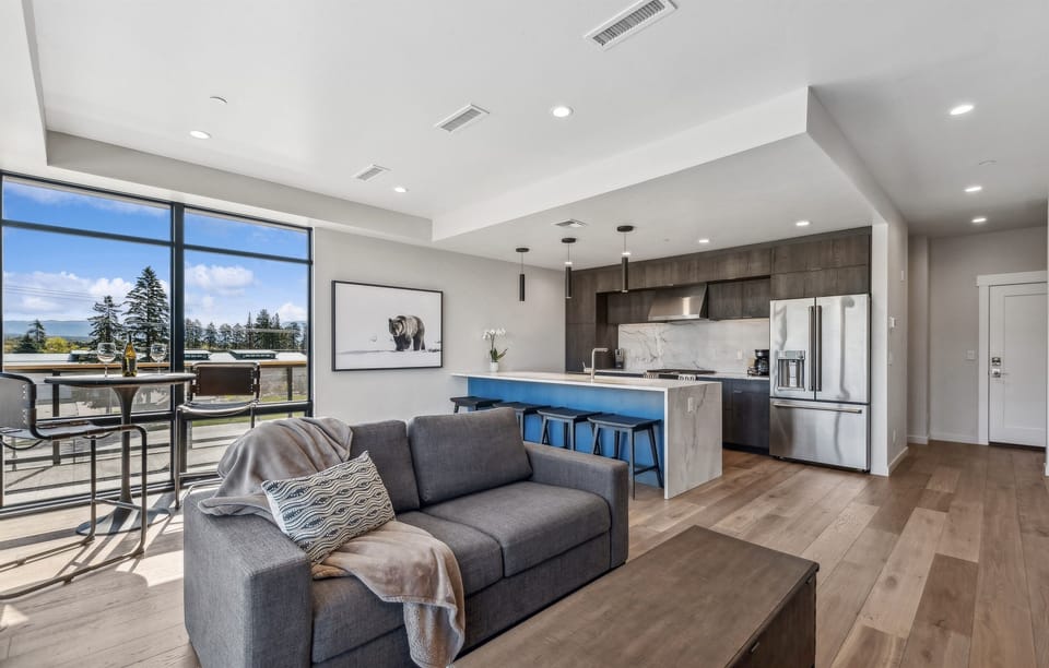 Main living space with open modern living room and kitchen. The living room features a luxury queen sofa sleeper.