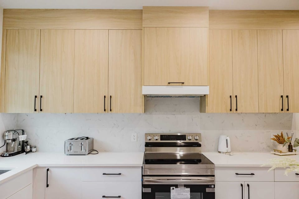 A modern cooking area featuring sleek countertop ,stainless appliances 