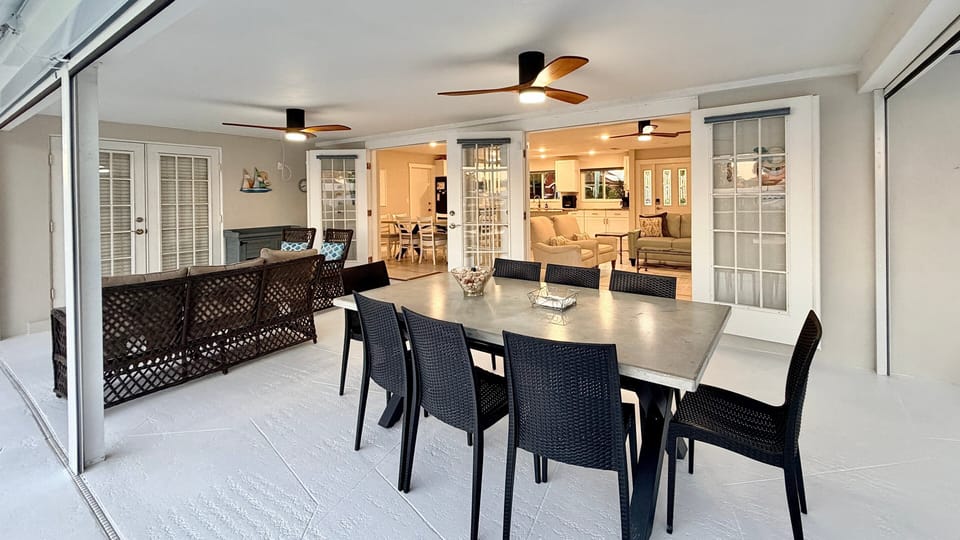 Sitting and dining areas in screened in lanai with ceiling fans