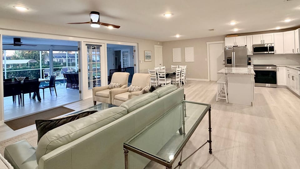 Living room with flat-screen TV and french doors opening to the lanai and pool